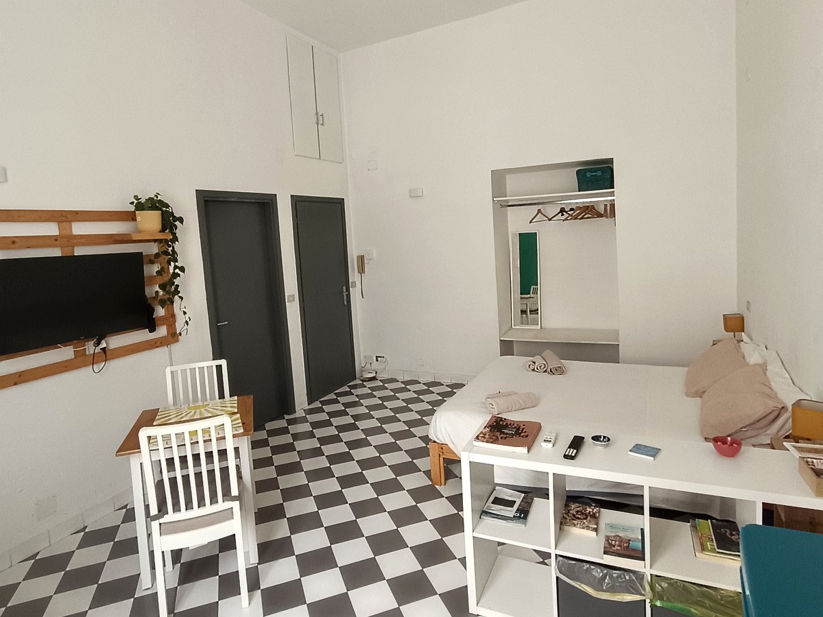 Monolocale spazioso con letto, armadio e pavimento a scacchi